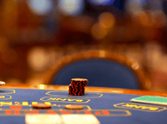 Interior de un casino con una mesa de paño verde en primer plano.