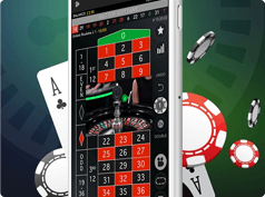 Teléfono móvil moderno de pantalla grande con una partida de ruleta en la pantalla, y fichas de poker y cartas de baraja francesa de fondo.