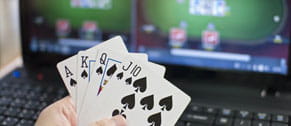 Jugador sujeta unas cartas mientras juega al póker online.